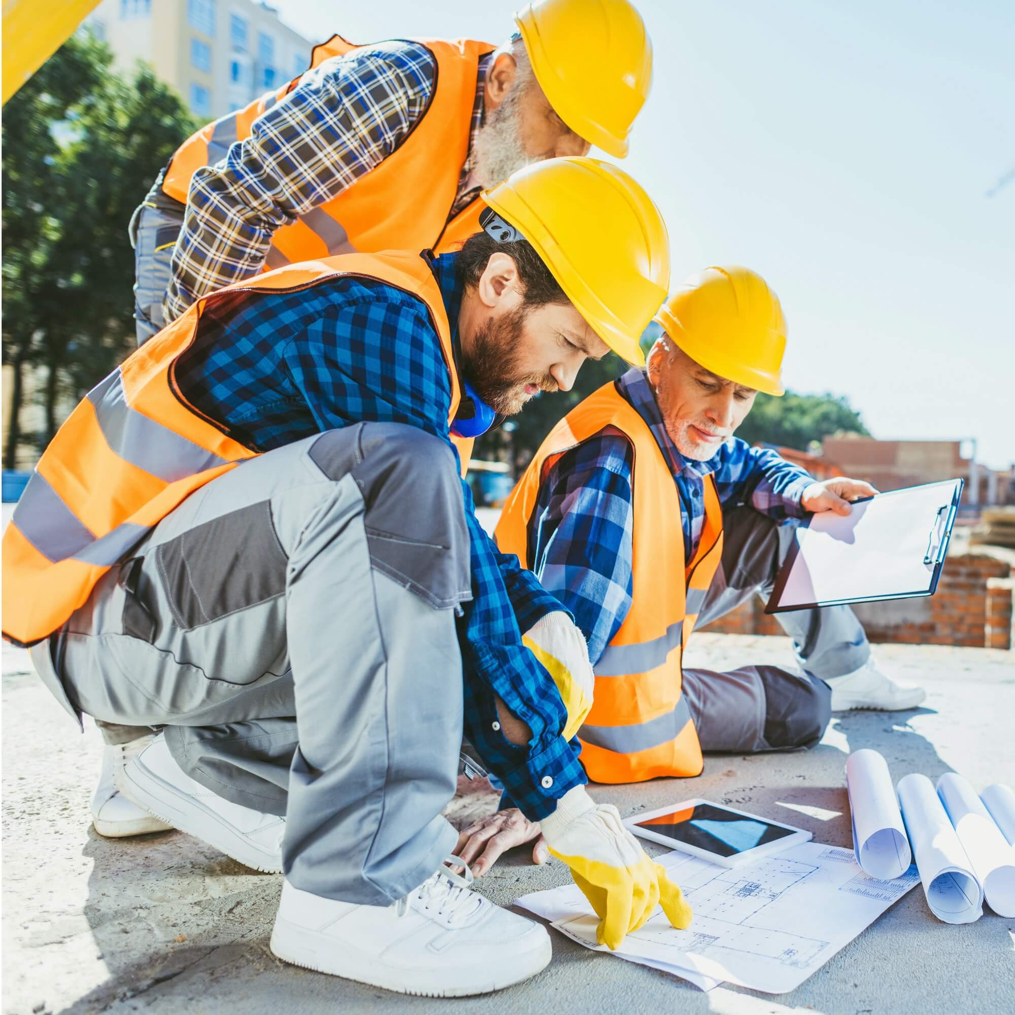 Excavaciones Coruña 7 handsome construction workers sitting on concrete at construction site discussing building plans 1